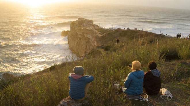 Friends watching the XXL waves at the Praia do Norte in Nazare Ⓒ AtlasPhotoArchive|Shuterstock.com 